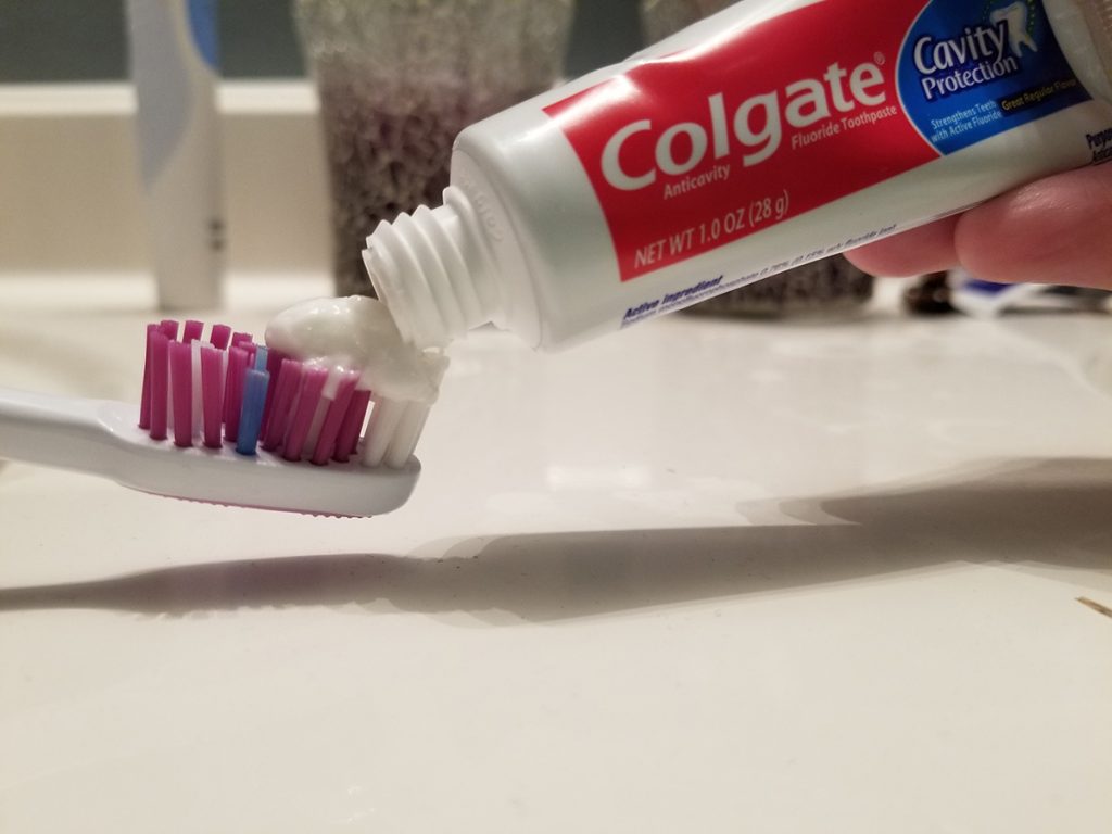 Colgate toothpaste on toothbrush.