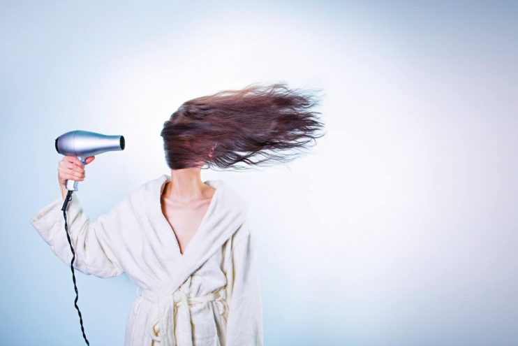 Best hair dryers hero, of girl blow drying hair.