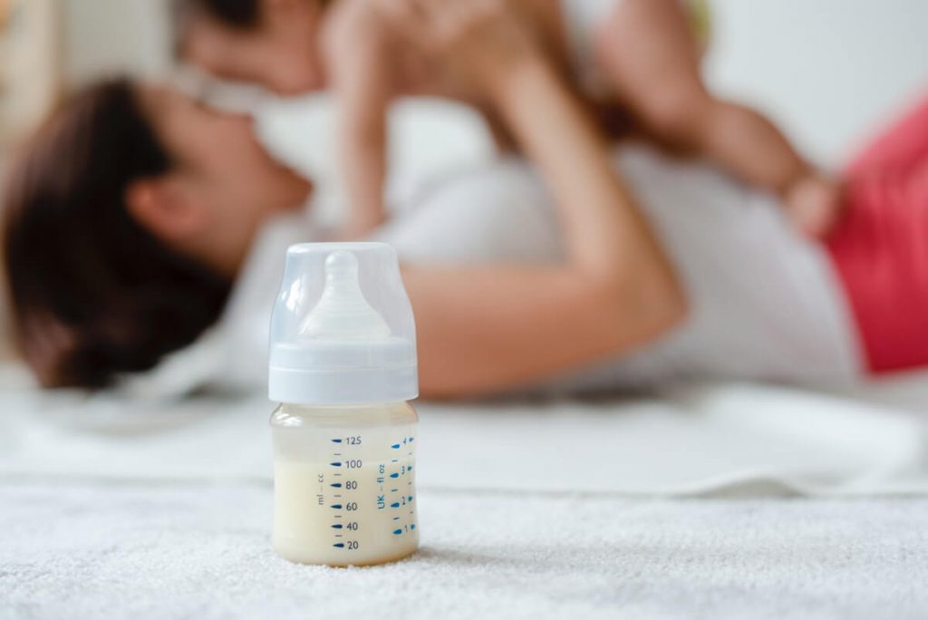 Baby with Mom and Formula inside a bottle.